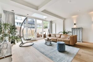 A person holding a rental agreement and house keys in a sunny living room with windows looking out to palm trees.